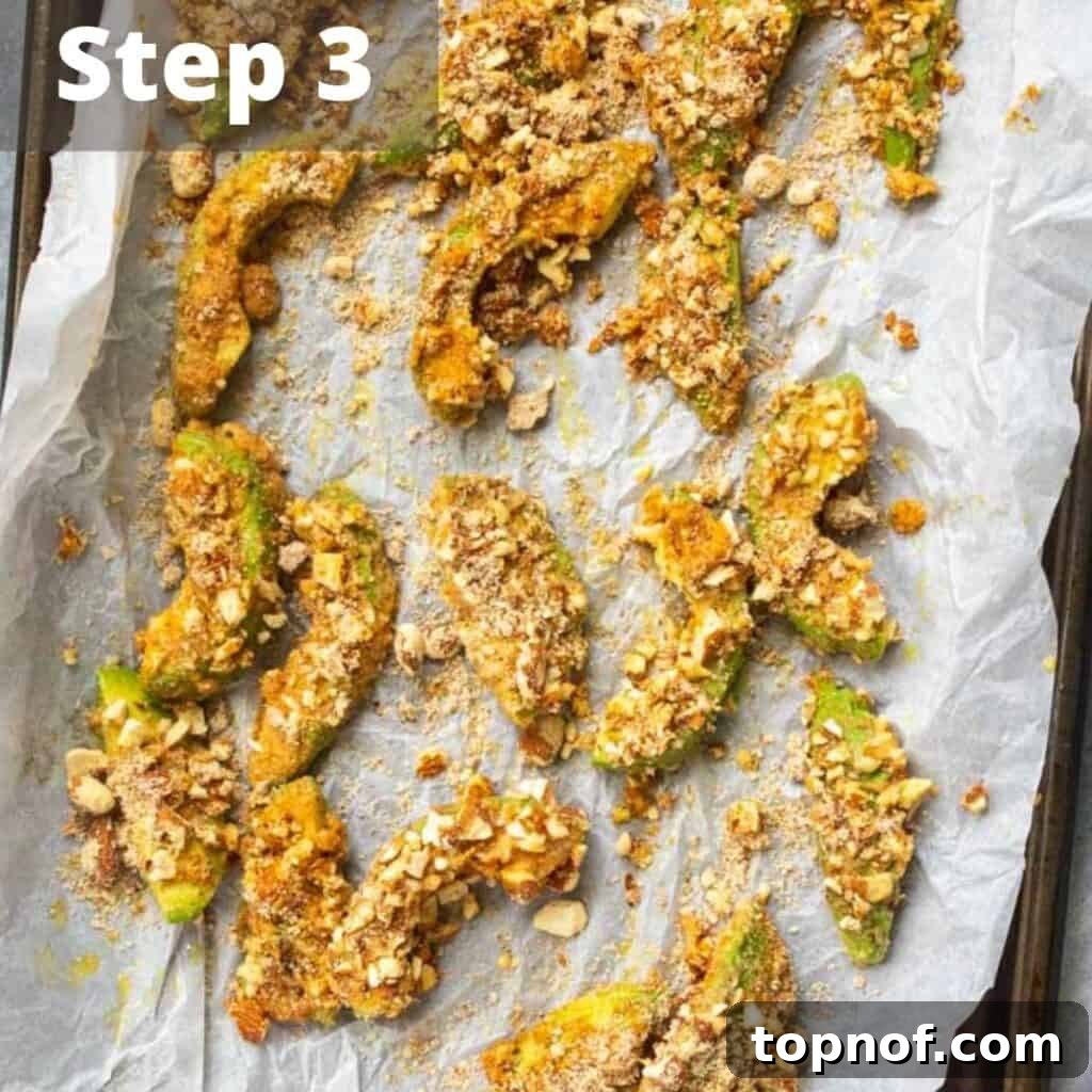 Oven-Crisped Avocado Fries 6 A close-up view of breaded avocado slices carefully arranged on a baking sheet, ready for the oven or air fryer.