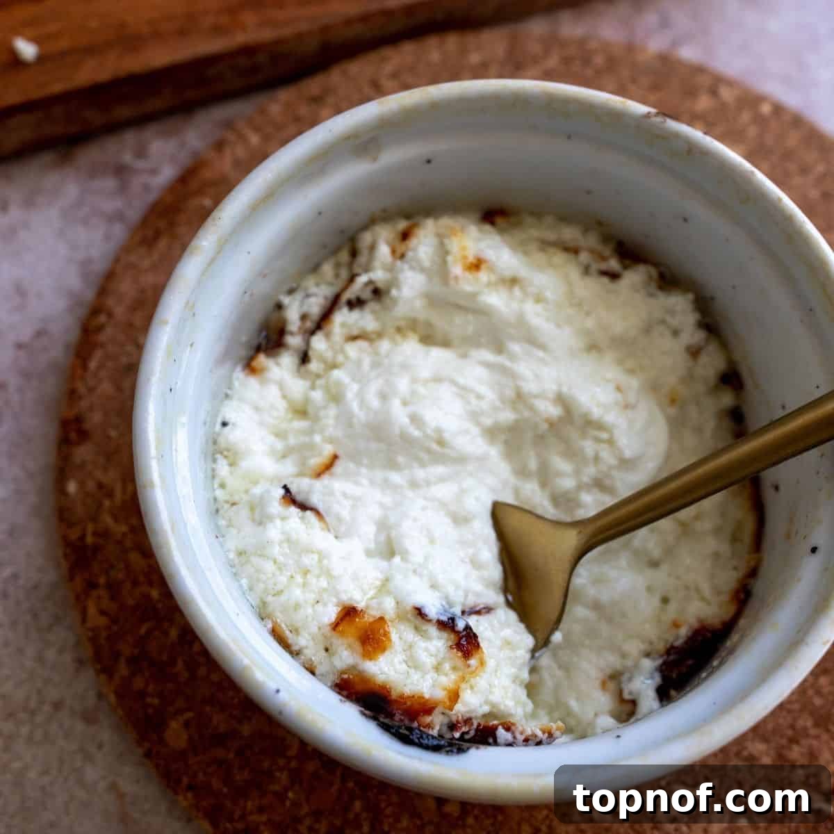 Up close shot of the baked goat cheese, highlighting its golden crust and creamy texture.
