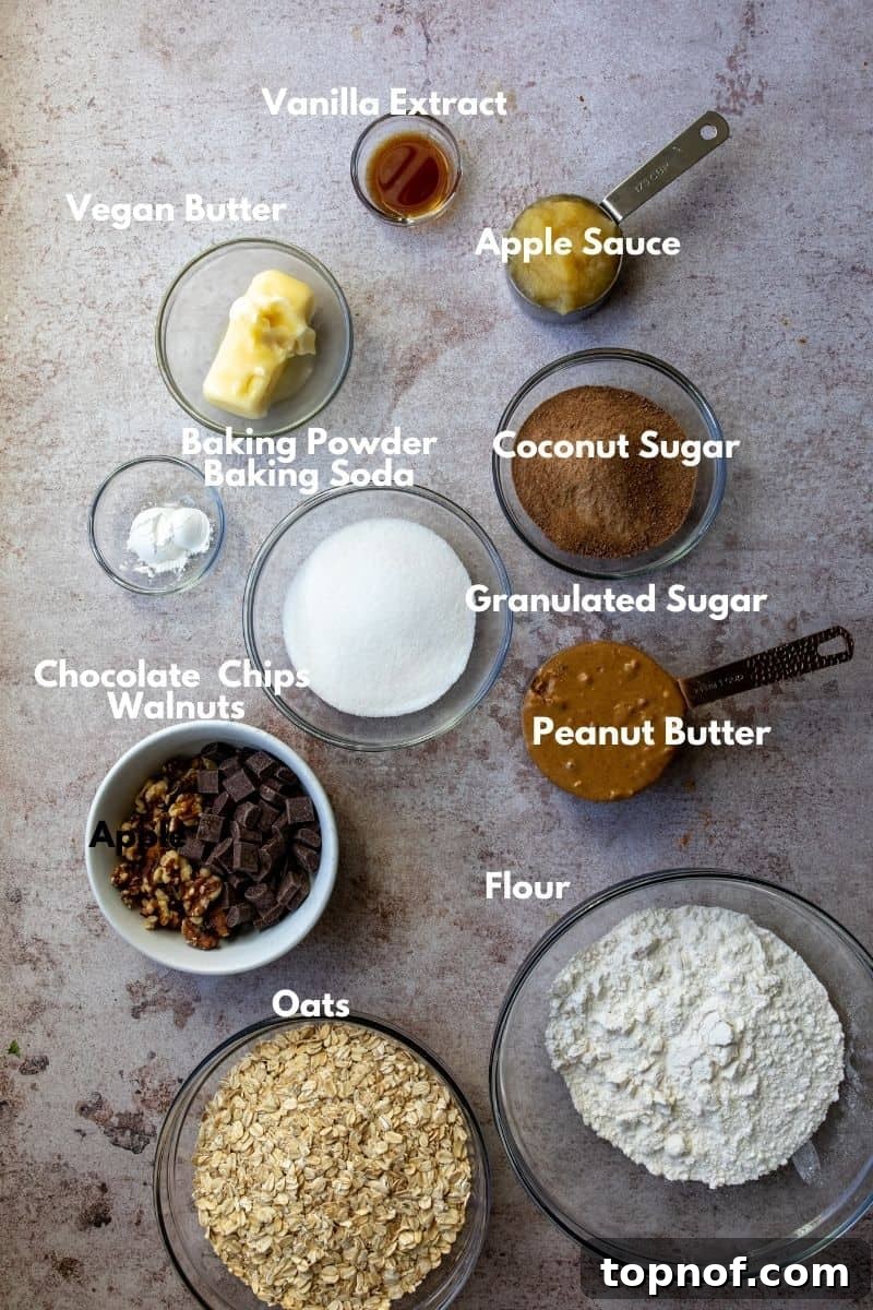Ultimate Chocolate Walnut Cookie Bars 3 A flat lay of all the vegan chocolate walnut cookie bar ingredients, including flour, vegan butter, oats, sugars, applesauce, peanut butter, vanilla, chocolate chips, and walnuts.