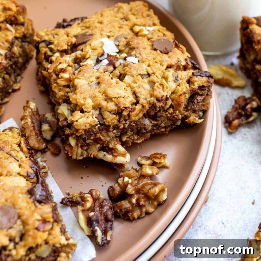 Ultimate Chocolate Walnut Cookie Bars 6 Baked vegan chocolate walnut cookie bars cooling in a baking pan, showing their golden-brown edges and soft interior texture.
