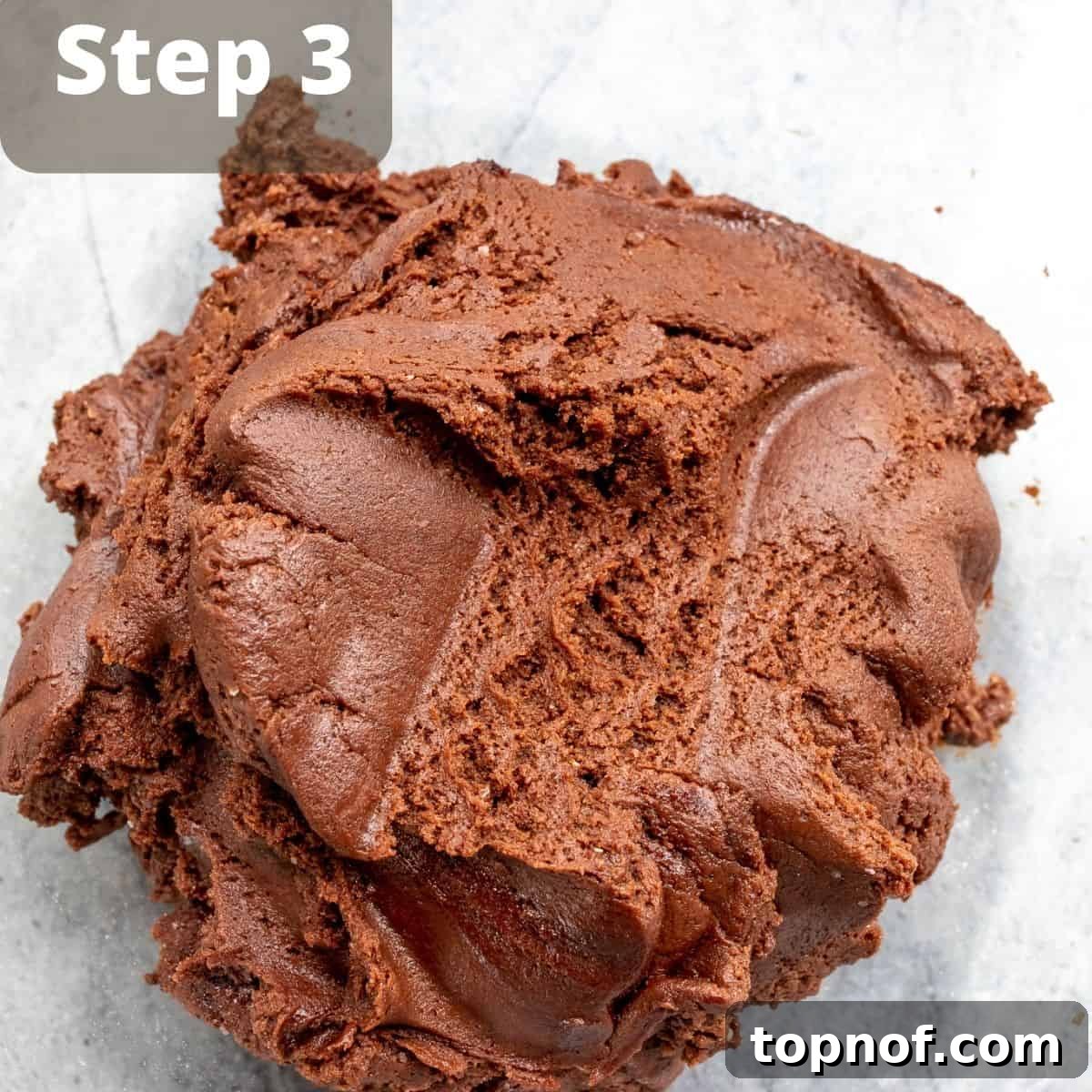Fudgy Chocolate Crinkle Cookies 5 Rolling brownie crinkle cookie dough balls in powdered sugar before baking.
