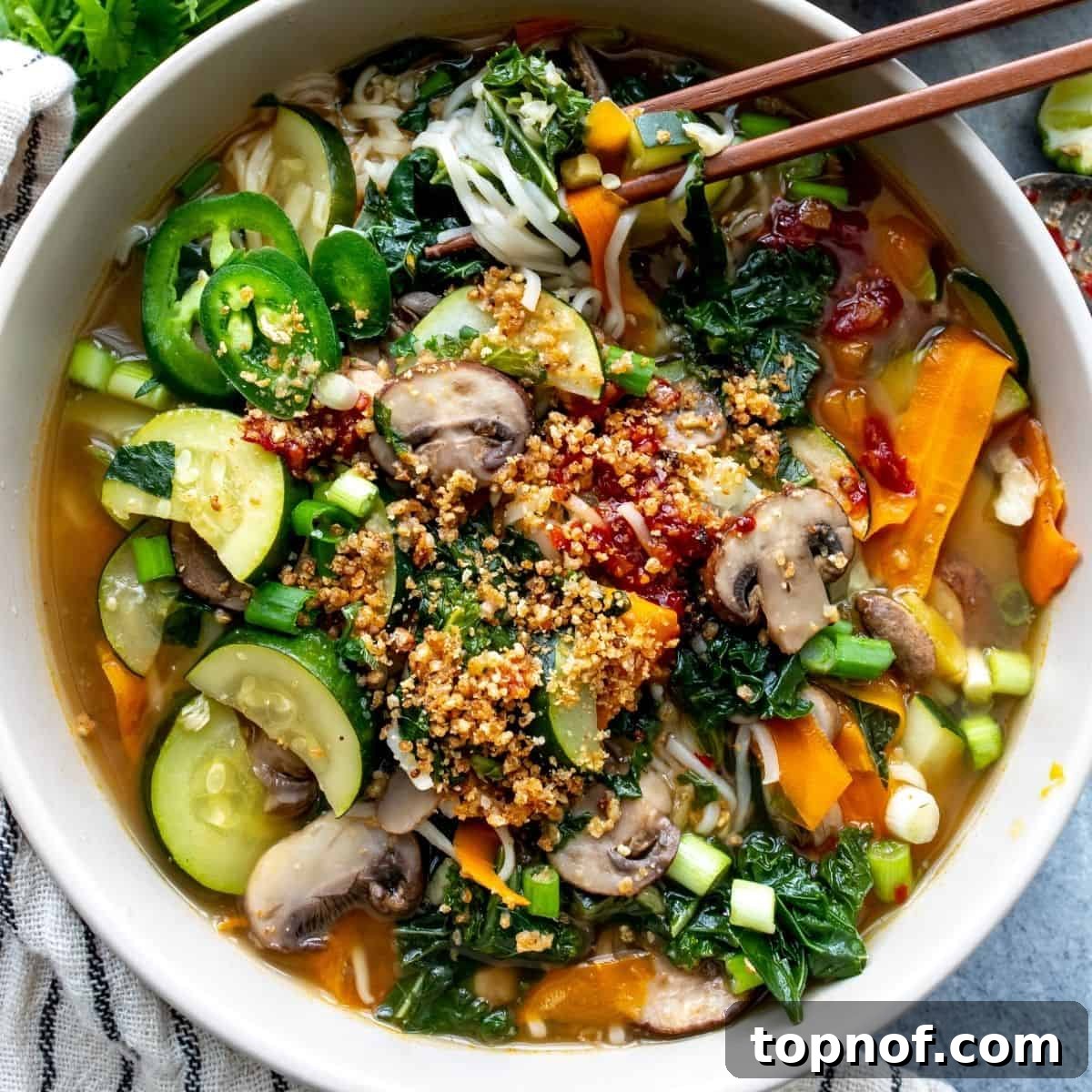 A vibrant bowl of homemade ramen, ready to eat, with chopsticks poised above the noodles and rich broth.