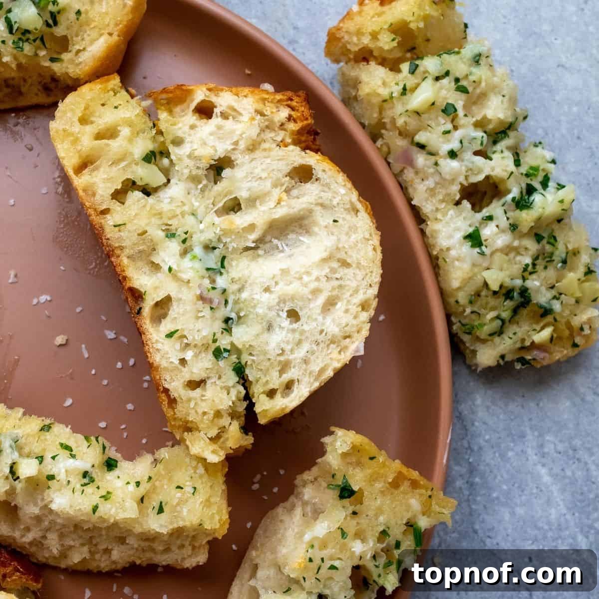Crispy Air Fryer Garlic Bread 6 Air Fryer Garlic Bread served on a peach plate with salt sprinkled on top, showcasing the finished product.