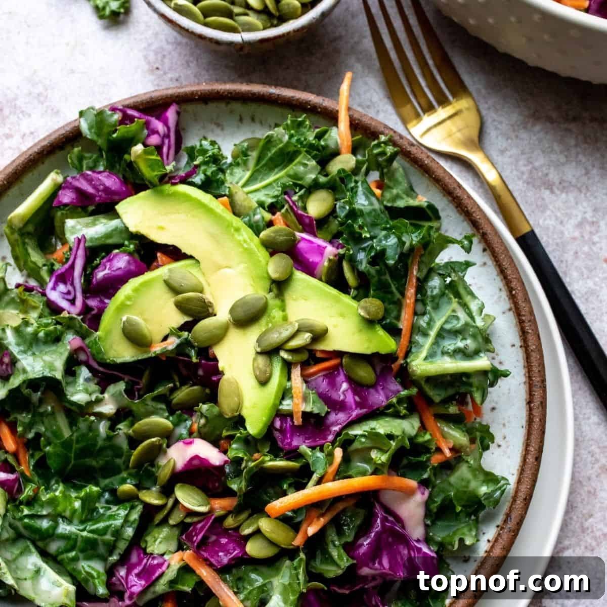 Vibrant Kale Slaw Perfection 2 A vibrant bowl of kale slaw with creamy dressing, garnished with fresh avocado slices.