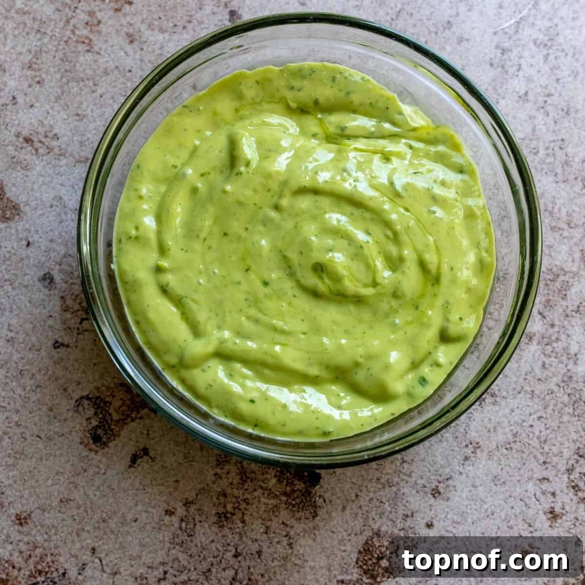 The creamy cilantro avocado dressing being blended, showing its smooth, vibrant green texture.