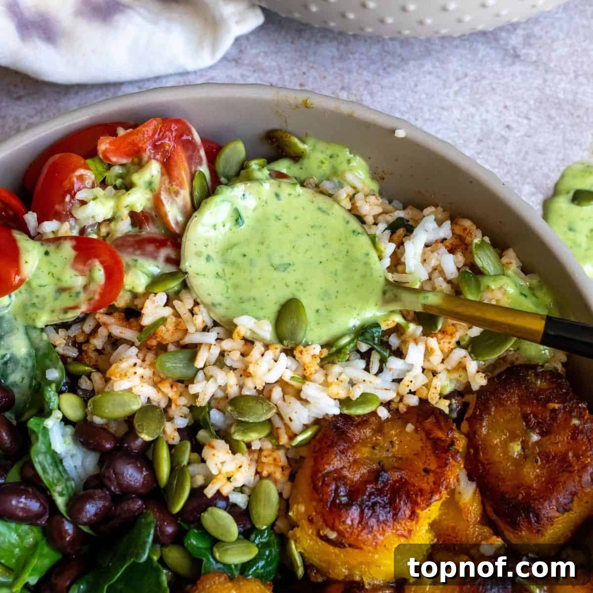 A close-up view of a completed vegan rice bowl, showcasing all its colorful and textured components in a gray bowl.