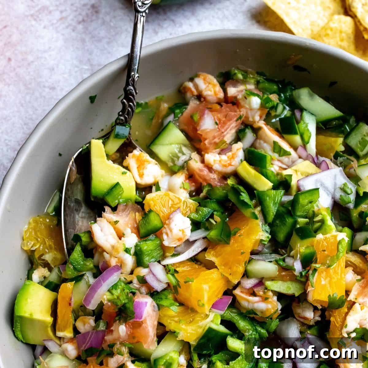 Close-up shot of Mexican shrimp ceviche in a clear glass bowl, showcasing the fresh ingredients and vibrant colors.