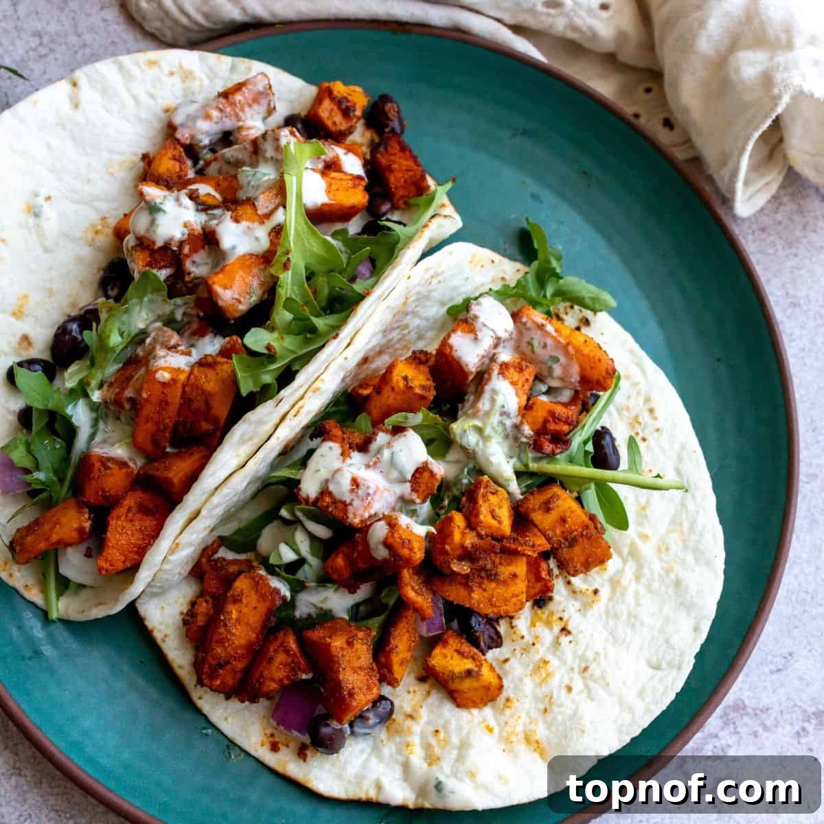 Plant-Powered Smoky Sweet Potato and Black Bean Tacos 5 Sweet Potato Black Bean Tacos on a green plate up close.
