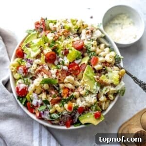 BLT Pasta Salad in a white bowl with a big spoon