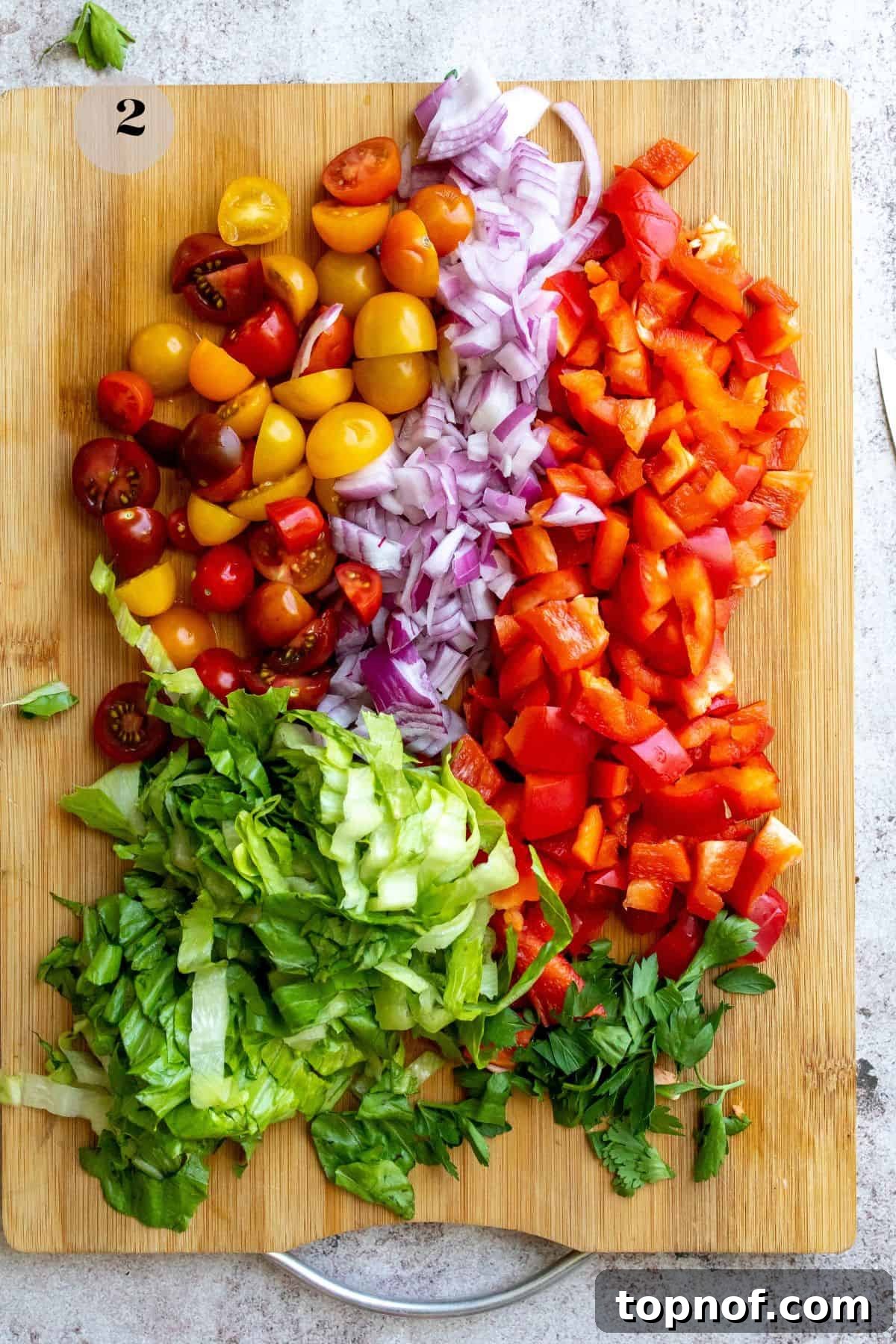 Savory BLT Pasta Toss 5 Assortment of chopped vegetables on a wooden cutting board, ready for assembling the BLT pasta salad.