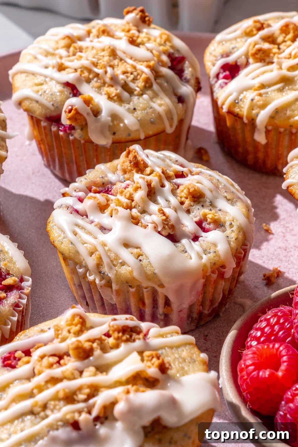 Sunshine Lemon Raspberry Muffins 2 Fluffy lemon raspberry muffins with powdered sugar glaze, ready to be enjoyed