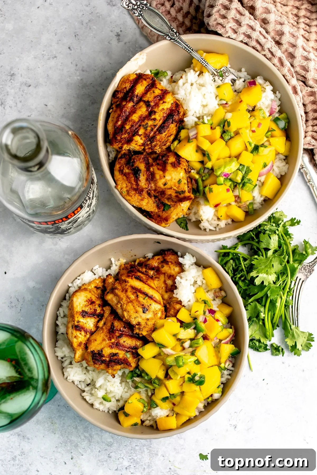 Citrus Tequila-Lime Chicken Recipe for Grilled Weeknight Meals 2 Ceramic bowl with tequila lime chicken thighs served over rice with mango salsa.