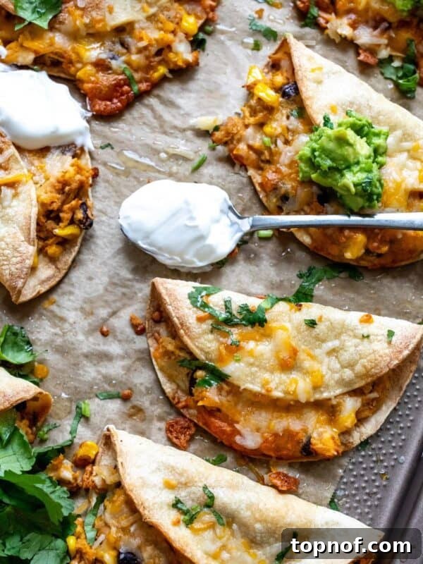 Citrus Tequila-Lime Chicken Recipe for Grilled Weeknight Meals 6 Crispy Chicken Tacos on a baking sheet with guacamole.