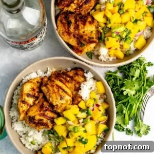 Citrus Tequila-Lime Chicken Recipe for Grilled Weeknight Meals 10 Tequila lime chicken served over rice and with mango salsa, tequila bottle on the side.