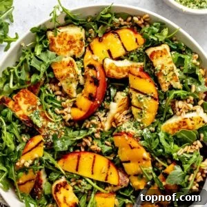 Grilled Peach and Halloumi Salad with Mint and Almonds 6 Peach and Halloumi Salad served in a ceramic bowl with pesto to the side.