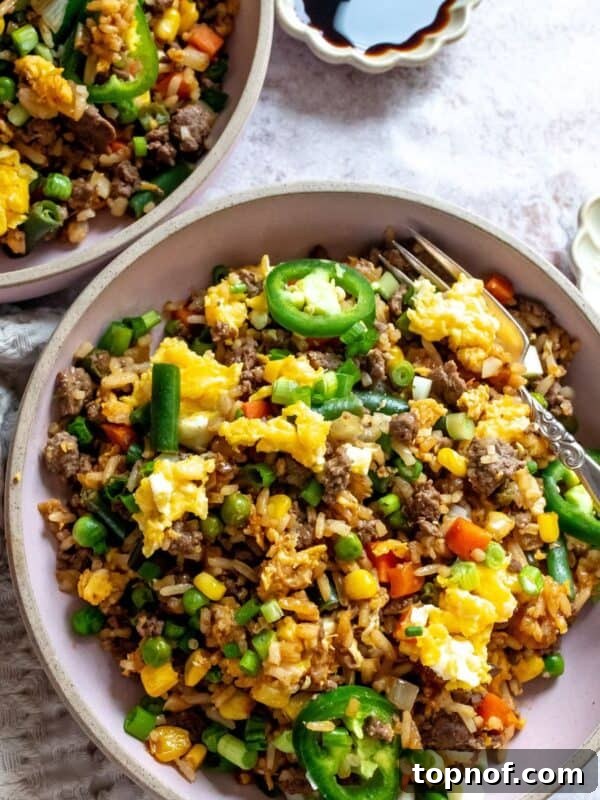 Street Corn Chicken Rice Bowls with Lime Crema 10 Pink bowl with ground beef fried rice in it, soy sauce to the side.
