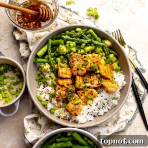 Hot Honey-Glazed Salmon with Crispy Skin 11 Ceramic bowl with hot honey salmon bites over rice with crispy asparagus and avocado.
