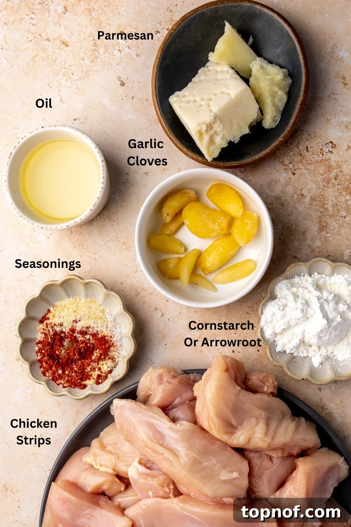 Crispy Garlic Parmesan Chicken Tenders Recipe 3 Ingredients in separated bowls laid out on a counter.