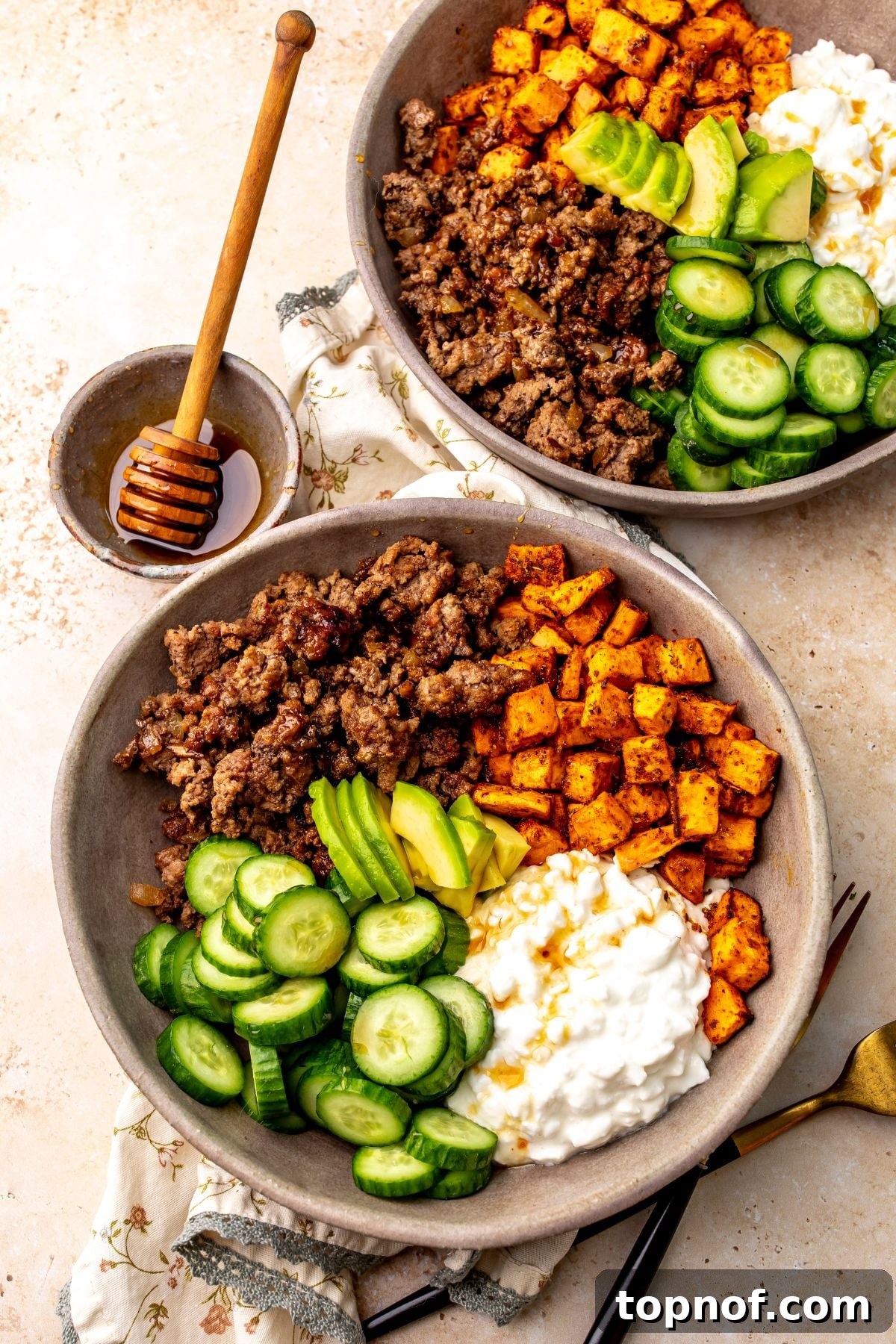 Spicy Honey Glazed Ground Beef Bowls 2 Two hot honey ground beef bowls on a countertop with a small bowl of hot honey on the countertop next to the bowls.