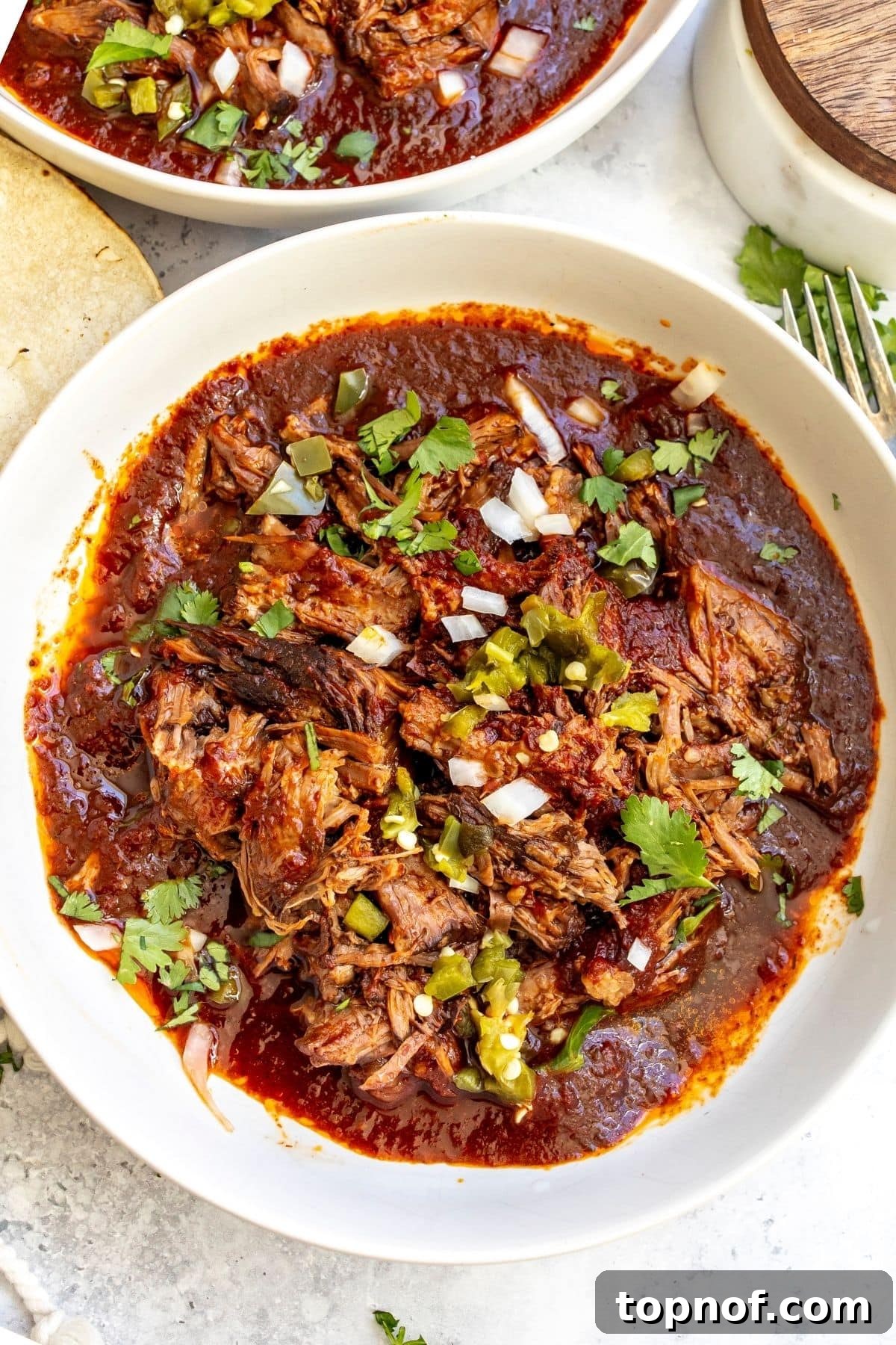 Slow Cooker Beef Birria Tacos with Dipping Consomme 8 Slow cooker beef birria in a white bowl after cooking.