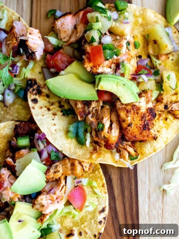 Tacos on a cutting board with blackened salmon.